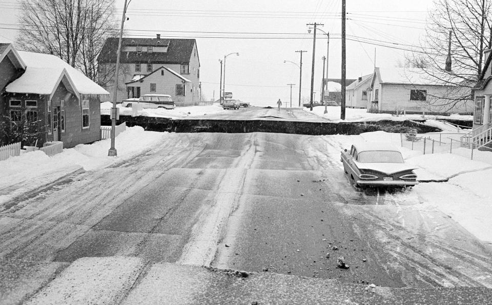 File - In this March 28, 1964 file photo, a huge crevasse is seen in the middle of a street in Anchorage, Alaska in the aftermath of an earthquake. One section of the street is several feet higher than the other. North America's largest earthquake rattled Alaska 50 years ago, killing 15 people and creating a tsunami that killed 124 more from Alaska to California. The magnitude 9.2 quake hit at 5:30 p.m. on Good Friday, turning soil beneath parts of Anchorage into jelly and collapsing buildings that were not engineered to withstand the force of colliding continental plates.(AP Photo/File)