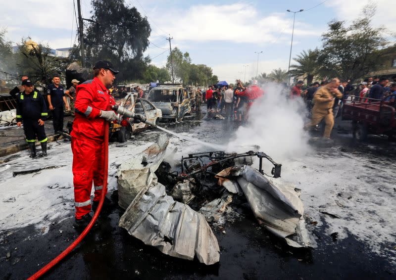 FILE PHOTO: A firefighter inspects the site of a car bomb attack in Sadr City district of Baghdad