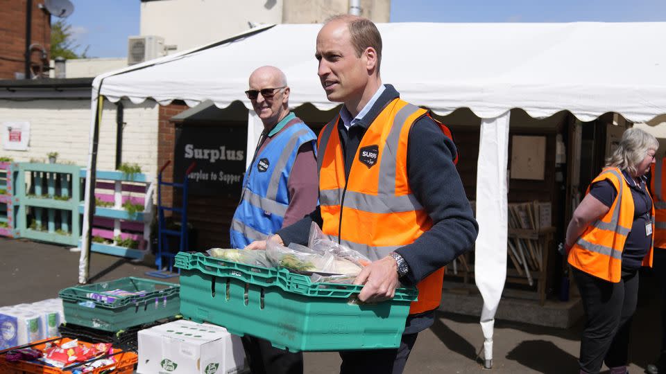 William helps load trays of food into vans for distribution. - Alastair Grant/Getty Images