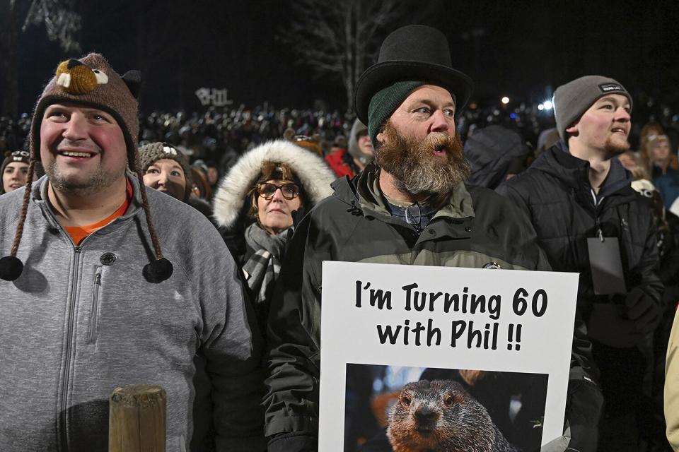 Rory Szwed, left, and Kent Rowan watch the festivities while waiting for Punxsutawney Phil