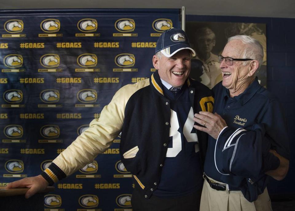 Dan Hawkins, who once played for UC Davis, wears his old jersey and letterman jacket during a press conference introducing him as the new Aggies head football coach in November 2016. Former Aggies head coach Bob Foster stands at right.