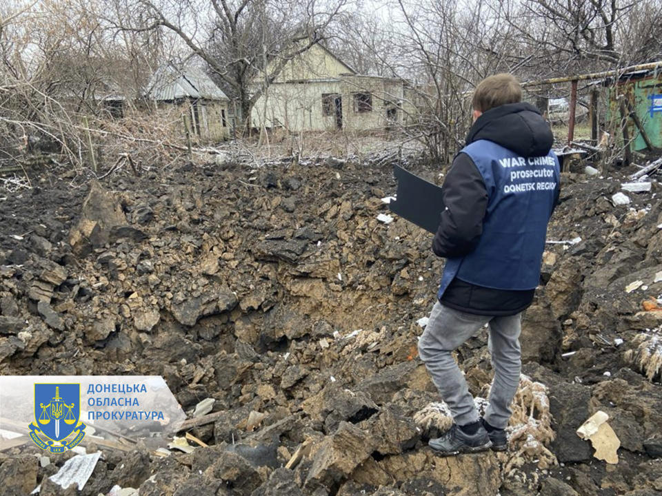 In this photo provided by the Donetsk Regional Prosecutor's Office, a war crime prosecutor inspects the scene after shelling in Pokrovsk, Ukraine, Thursday, Nov. 30, 2023. (Ukrainian Donetsk Regional Prosecutor's Office via AP)
