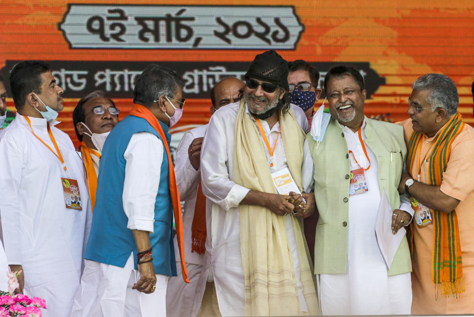 Bollywood actor Mithun Chakrabarty, third right, is greeted on dais by Bharatiya Janata Party leaders, Dilip Ghosh, right, Mukul Roy, second right and Suvendu Adhikari, left prior to joining the party ahead of West Bengal state elections in Kolkata, India, Sunday, March 7, 2021. (AP Photo/Bikas Das)