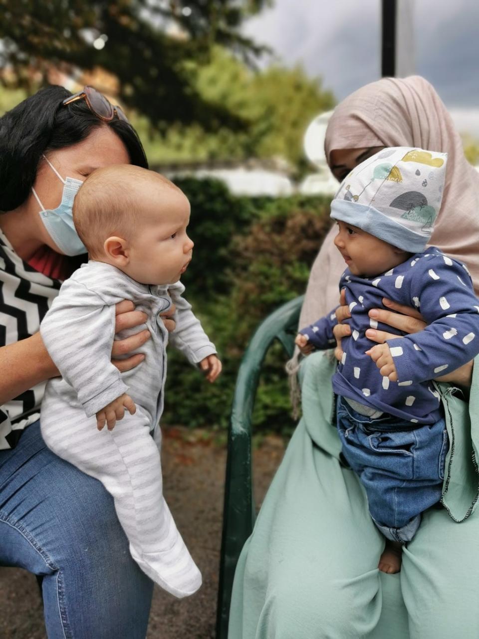 Alexandra Kenchington with her four-month old son, Barney, looking at the four-month old daughter, Madiha, of Afghan refugees (Matt Simmons/PA).