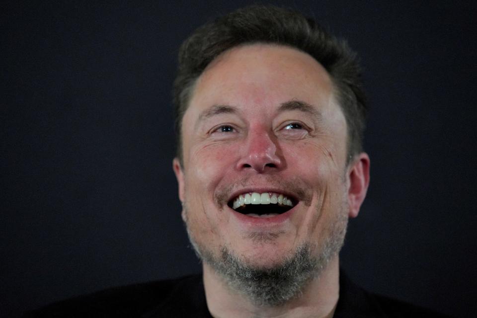 elon musk head laughing against black background