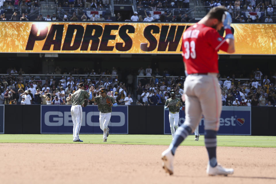 San Diego Padres right fielder Wil Myers (5) and shortstop Ha-Seong Kim celebrate as Cincinnati Reds' Jesse Winker, right, reacts after popping out to end a baseball game Sunday, June 20, 2021, in San Diego. (AP Photo/Derrick Tuskan)