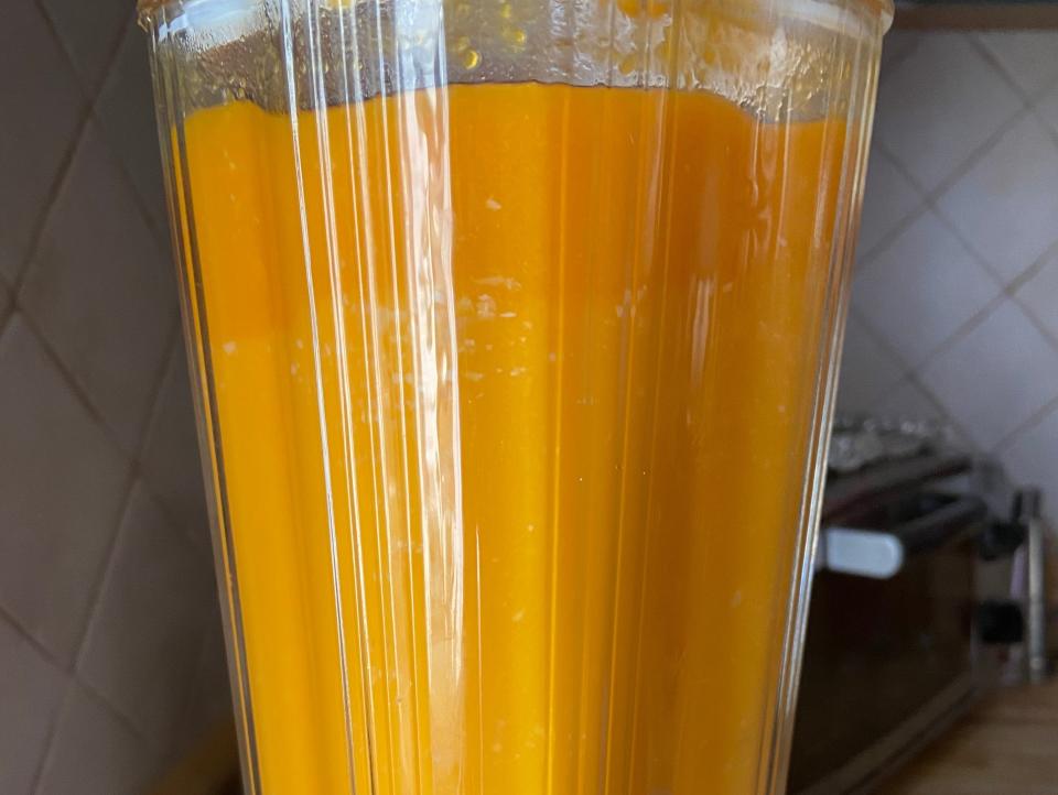 A blender filled with orange squash