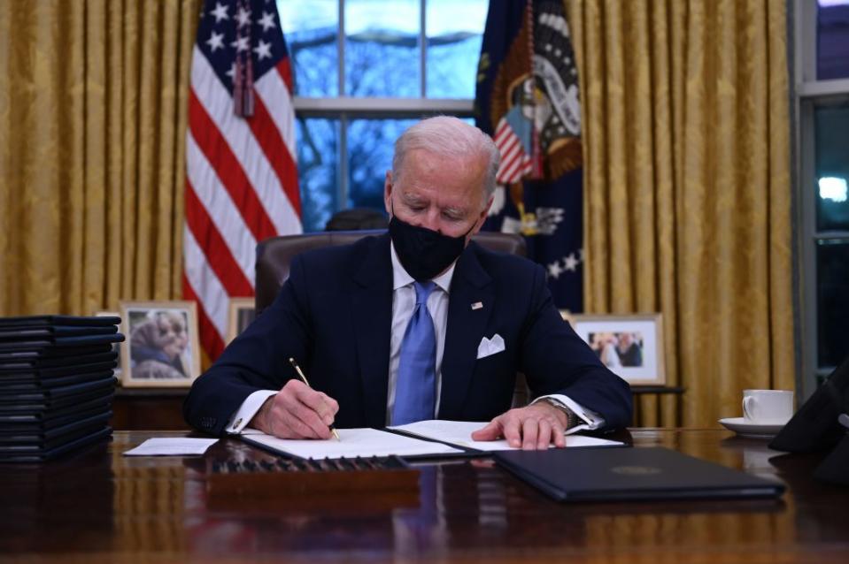 <p>In between being sworn in on the steps of the Capitol and watching a primetime concert to celebrate his new presidency, Biden got straight to work - heading to the Oval Office to sign several Executive Orders.</p><p>Among them were: Mandating the wearing of masks on federal property to protect people from Coronavirus, re-joining the Paris Climate Change agreement which Donald Trump controversially pulled the US out of, ended an Trump-ordered travel ban from Muslim-majority countries and stopped the funding of that infamous 'wall' between the US and Mexico, <a href="https://www.bbc.co.uk/news/world-us-canada-55738746" rel="nofollow noopener" target="_blank" data-ylk="slk:reports the BBC.;elm:context_link;itc:0;sec:content-canvas" class="link ">reports the BBC.</a></p>