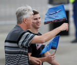 Guests wave flags introducing the first flight of the new Boeing 787-10 Dreamliner at the Charleston International Airport in North Charleston, South Carolina, United States March 31, 2017. REUTERS/Randall Hill