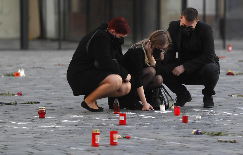 People pay respect to victims of the COVID-19 pandemic at a spontaneous memorial place set at the Old Town Square in Prague, Czech Republic, Monday, March 29, 2021. The coronavirus pandemic is unleashing enormous suffering as infection rates rise across central Europe even as the Czech Republic and Slovakia, recently among the worst-hit areas in the world, are finally seeing some improvements following tight lockdowns. (AP Photo/Petr David Josek)