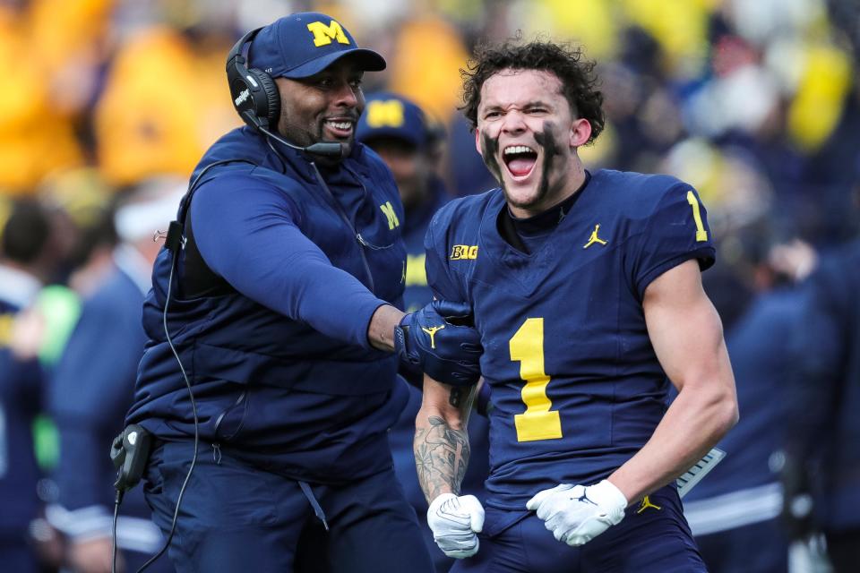 Michigan receiver Roman Wilson and acting head coach/offensive coordinator Sherrone Moore celebrate Wilson's touchdown catch against Ohio State during the first half at Michigan Stadium in Ann Arbor on Saturday, Nov. 25, 2023.
