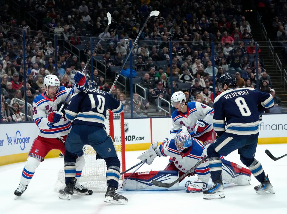 Feb. 25, 2024; Columbus, Ohio, USA; 
New York Rangers goaltender Jonathan Quick (32) reaches to grab a puck as Columbus Blue Jackets left wing Dmitri Voronkov (10) is defended by New York Rangers defenseman Erik Gustafsson (56) during the first period of an NHL game at Nationwide Arena on Sunday.