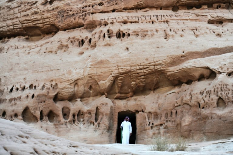 A man stands at the entrance to a tomb at the UNESCO World Heritage site of Madain Saleh in Saudi Arabia on March 31, 2018