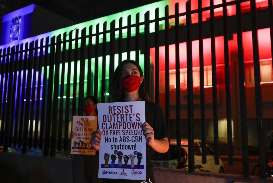 Activists hold slogans outside the headquarters of broadcast network ABS-CBN corp. on Tuesday, May 5, 2020 in Quezon city, Metro Manila, Philippines. A Philippine government agency has ordered the country's leading broadcast network, which the president has targeted for it's critical news coverage, to halt operations after its congressional franchise expired, sparking shock over the loss of a major news provider during the coronavirus pandemic. (AP Photo/Aaron Favila)