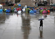 Protestors of the environmental activist group extinction rebellion camp during a demonstration during a rainy morning at Trafalgar Square in London, Monday, Oct. 14, 2019.(AP Photo/Frank Augstein)