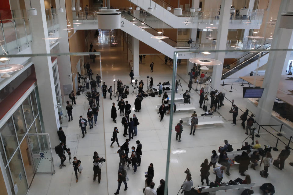 Journalists gather in the hall of the Paris Hall of Justice for the opening of the 2015 attacks trial, Wednesday, Sept. 2, 2020 in Paris. Thirteen men and a woman go on trial Wednesday over the 2015 attacks against a satirical newspaper and a kosher supermarket in Paris that marked the beginning of a wave of violence by the Islamic State group in Europe. Seventeen people and all three gunmen died during the three days of attacks in January 2015. (AP Photo/Francois Mori)