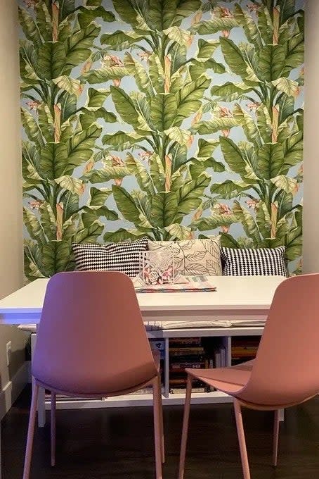 a reviewer photo of the tropical wallpaper on a small dining room accent wall