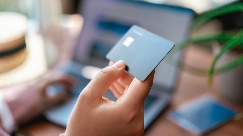 best time to buy appliances: Woman paying for tickets on vacation. Online travel booking using computer. Business trip planning. Selective focus. Credit card in hand close up