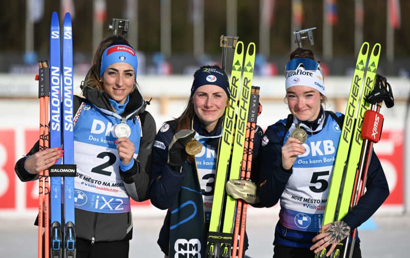 (L-R) Italy's secnond-placed Lisa Vittozzi, France's first-placed Justine Braisaz-Bouchet, and France's third-placed Lou Jeanmonnot celebrate with their medals after winning the women's mass start 12.5 km during the Biathlon World Championships in Nove Mesto Na Morave Hendrik Schmidt/dpa