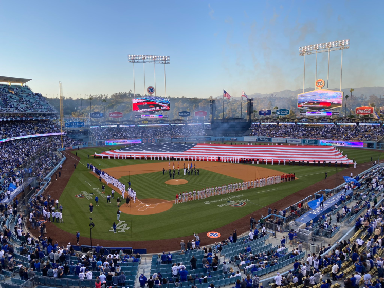 A giant American flag covers the field at Dodger Stadium before the start of the Dodgers' home opener