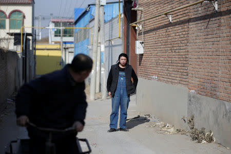 A neighbour looks at Geng Shuai, dubbed "Useless Edison" by his fans, in Yangcun village of Baoding, Hebei province, China January 22, 2019. REUTERS/Jason Lee