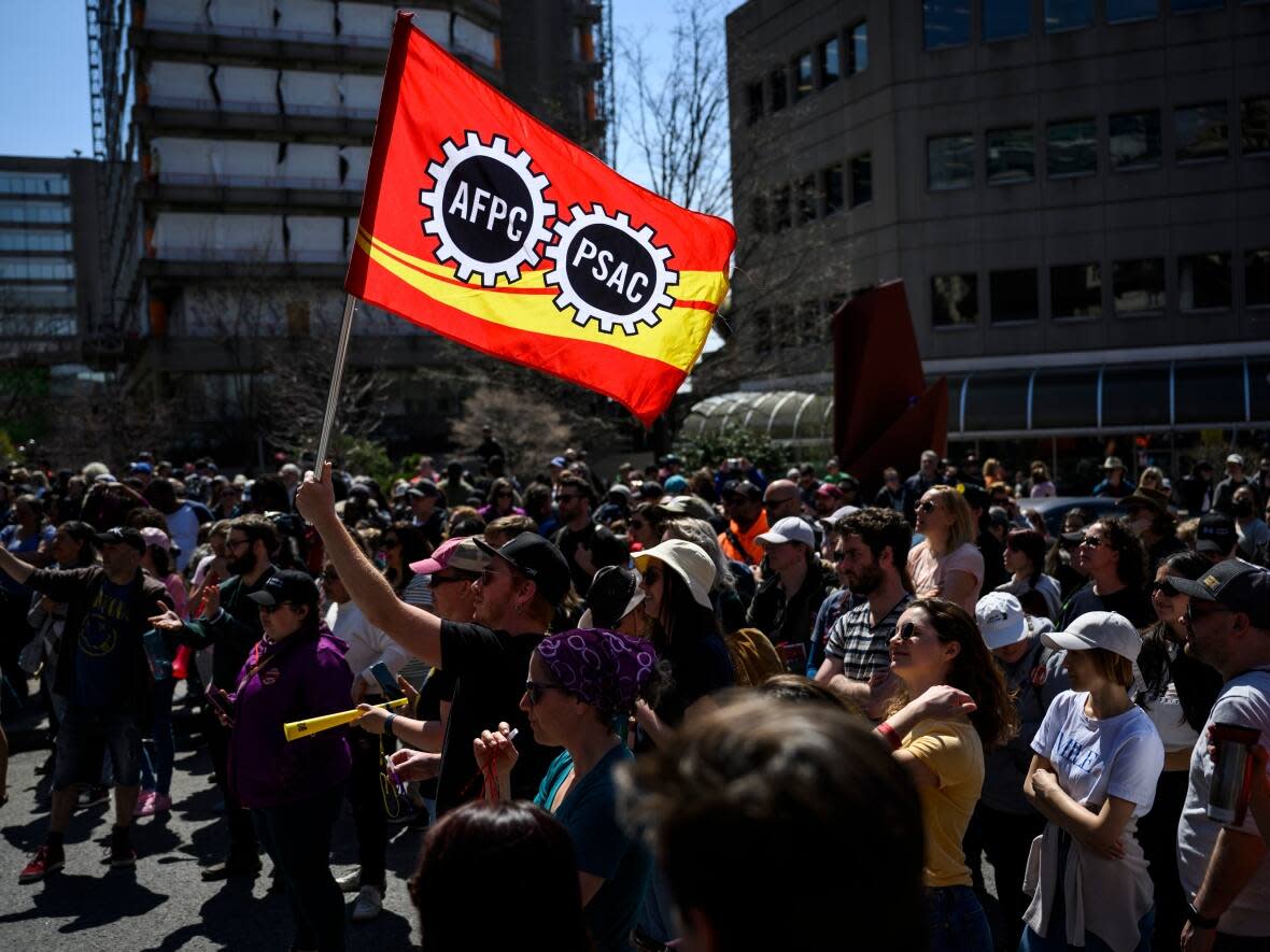 Public Service Alliance of Canada members watch a performance Friday outside Place du Portage in Gatineau, Que. While about 96 per cent of eligible PSAC members are on the picket line, some say they're choosing instead to work during the labour disruption. (Justin Tang/The Canadian Press - image credit)