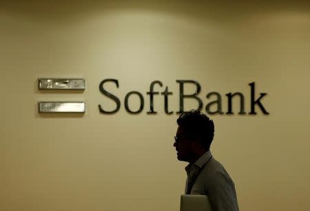 A man walks past the logo of SoftBank Group Corp at the company's headquarters in Tokyo, June 30, 2016. REUTERS/Toru Hanai