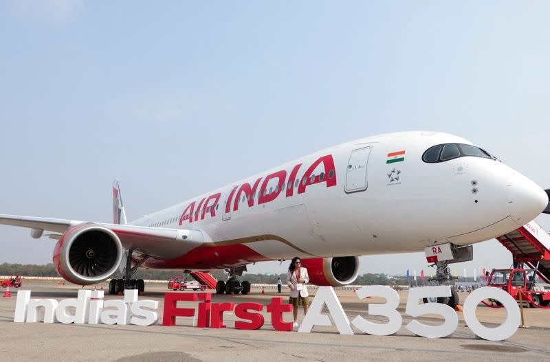 FILE PHOTO: A woman stands next to the Air India Airbus A350 aeroplane, displayed at Wings India 2024 aviation event at Begumpet airport, Hyderabad