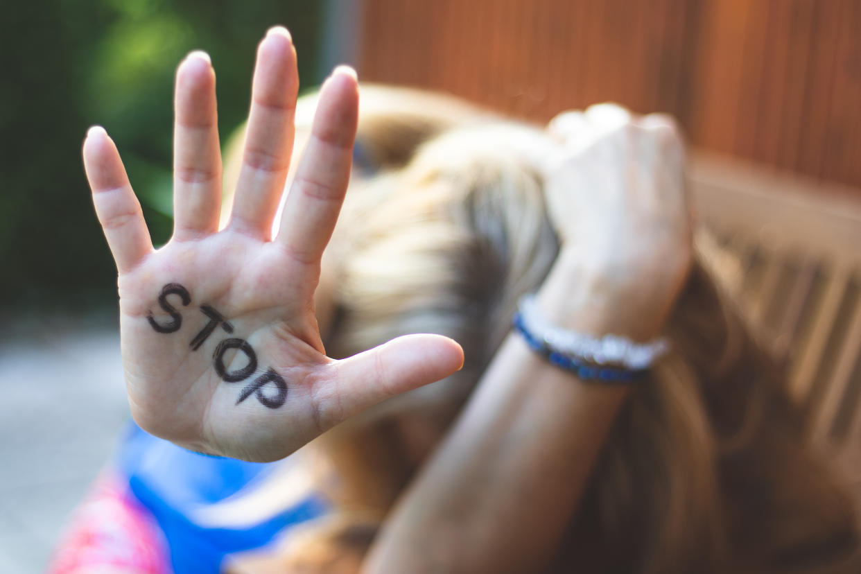 Selective focus on open females hand with written stop sign.