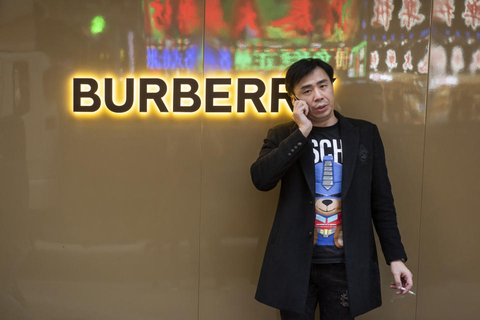 HONG KONG, CHINA - 2019/12/08: A man uses his phone outside of the British luxury fashion brand Burberry store and logo in Hong Kong. (Photo by Budrul Chukrut/SOPA Images/LightRocket via Getty Images)