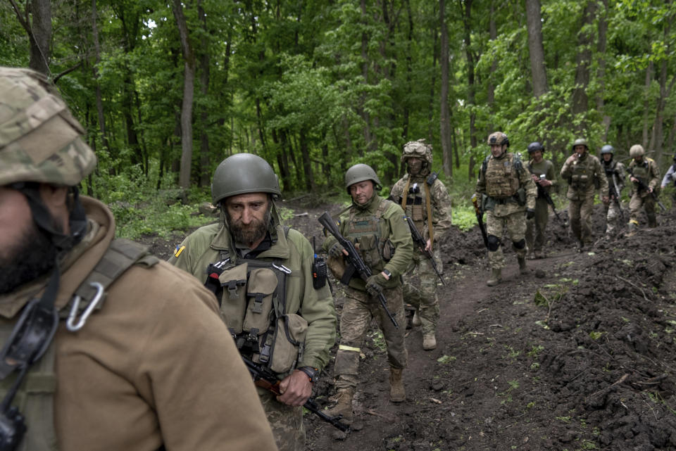 Militares ucranianos caminan el domingo 15 de mayo de 2022 por el bosque cerca de un pueblo recién recuperado, al norte de Járkiv, en el este de Ucrania. (AP Foto/Mstyslav Chernov)