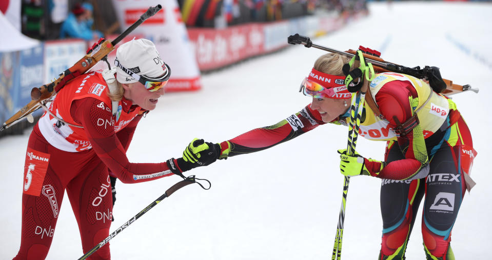 Winner Gabriela Soukalova of Czech Republic, right, congratulates second placed Tora Berger of Norway after the women's Pursuit 10 km competition at the Biathlon World Cup in Ruhpolding, Germany, Sunday, Jan, 12, 2014. (AP Photo/Matthias Schrader)