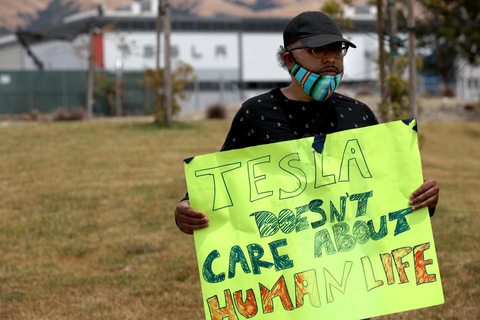 Tesla worker Carlos Gabriel holds a sign at a demonstration outside the Tesla plant in Fremont, California, on June 15, protesting working conditions there. (Photo: Justin Sullivan via Getty Images)