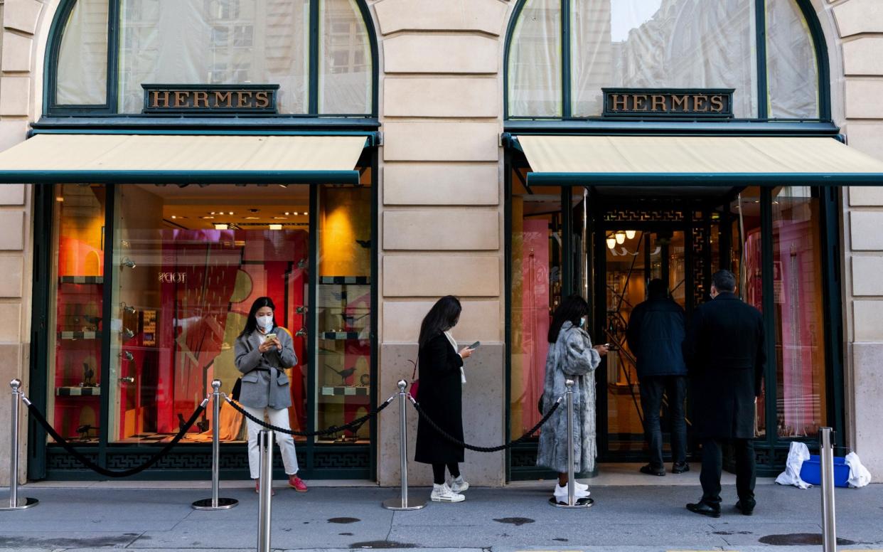 Shoppers form a socially distanced queue to enter a Hermes International luxury good boutique in Paris, France - Benjamin Girette/Bloomberg