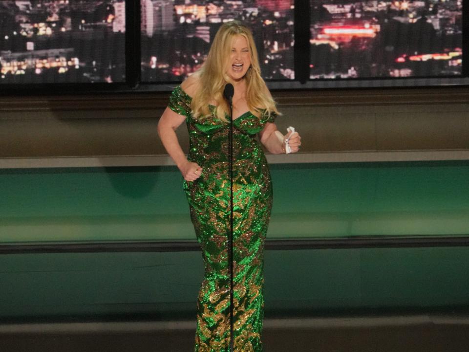 jennifer coolidge in a sparkling emerald dress dancing onstage at the emmys