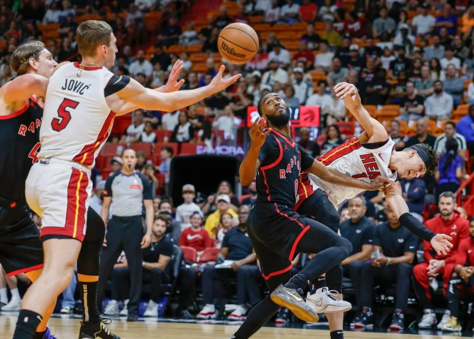 El jugador del Heat Nikola Jovic (5) y Javon Freeman-Liberty (0), de los Raptors de Toronto, tratan de recuperar un balón en el partido celebrado el 14 de abril de 2024 en Miami.