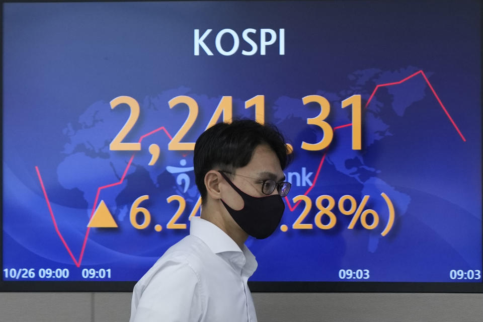 A currency trader walks near a screen showing the Korea Composite Stock Price Index (KOSPI) at a foreign exchange dealing room in Seoul, South Korea, Wednesday, Oct. 26, 2022. Asian stock markets followed Wall Street higher on Wednesday as hopes rose that the Federal Reserve might ease off plans for interest rate hikes and Britain installed its third prime minister this year. (AP Photo/Lee Jin-man)