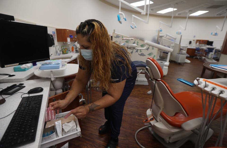 Carmen Franco, a dental assistant at the pediatric dentistry at Eastman Dental, brings out supplies for a tooth extraction