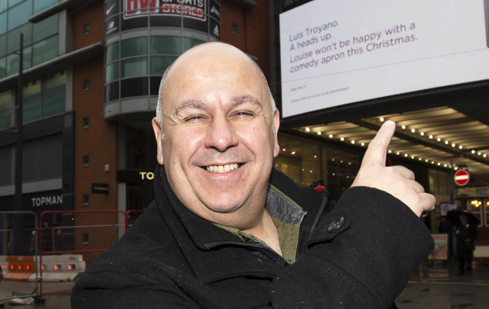 EDITORIAL USE ONLY Luis Troyano, one of the Great British Bake Off finalists receives a personalised Christmas gift hint from his wife as part of Currys PC WorldÕs Spare the Act campaign outside the Arndale centre in Manchester.