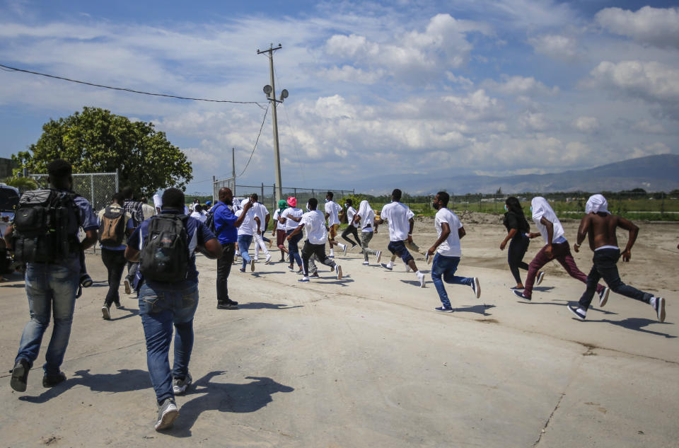 FILE - Haitians deported from the United States run back to the tarmac to try to get back on the same plane they traveled in, in an attempt to return to the United States, at the Toussaint Louverture International Airport, in Port-au-Prince, Haiti Sept. 21, 2021. The country is struggling to cope with the recent arrival of more than 12,000 deported Haitians, the majority from the U.S. (AP Photo/Joseph Odelyn, File)