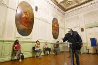 A man wearing a face mask to protect against coronavirus infection casts his ballot at a polling station in St.Petersburg, Russia, Wednesday, July 1, 2020. The vote on the constitutional amendments that would reset the clock on Russian President Vladimir Putin's tenure and enable him to serve two more six-year terms is set to wrap up Wednesday. (AP Photo/Dmitri Lovetsky)