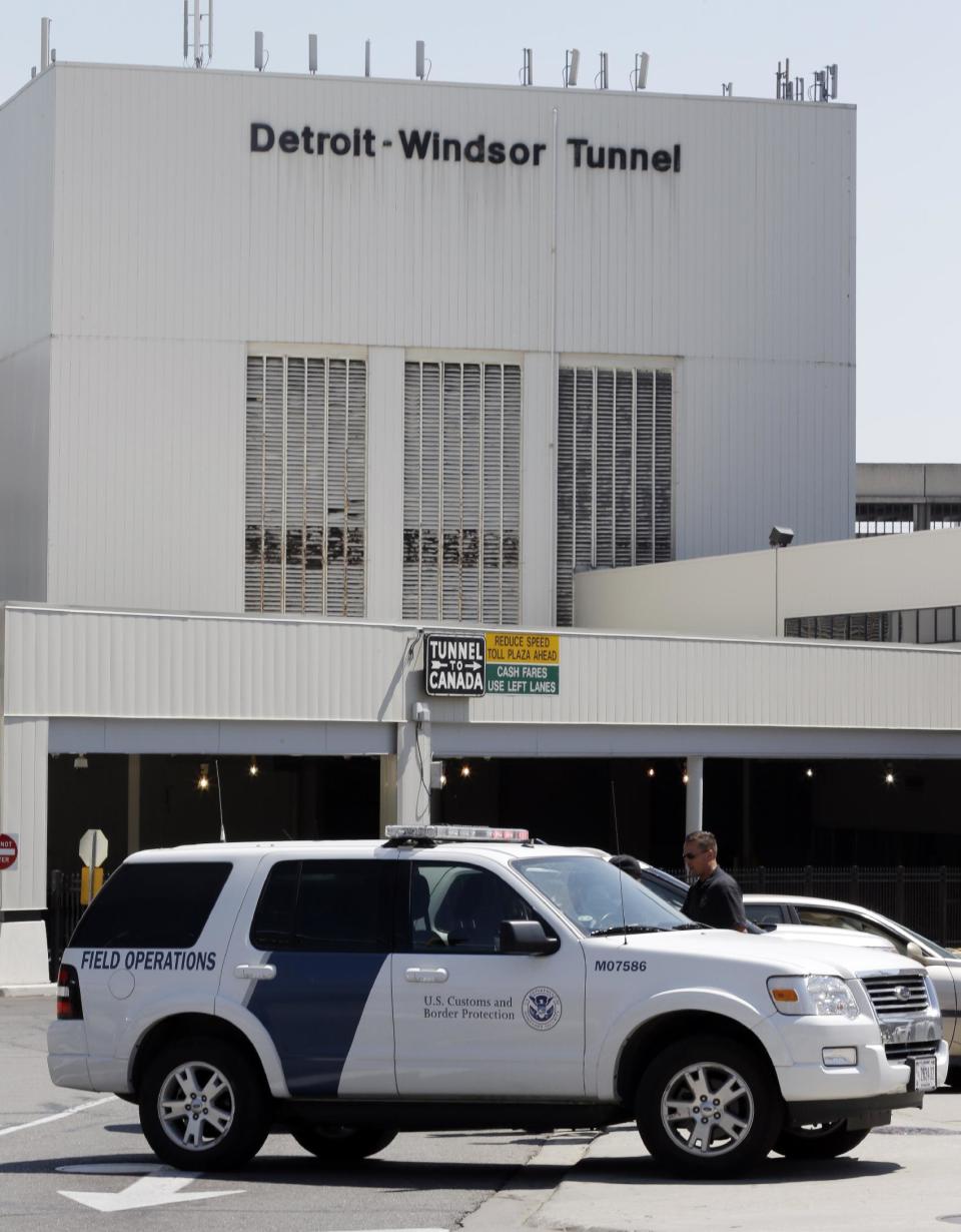 Vehicles block the entrance as authorities investigate a bomb threat at the Detroit Windsor Tunnel Thursday, July 12, 2012. The tunnel was closed to traffic after the threat was called in on the Canadian side, tunnel chief executive Neal Belitsky told The Associated Press. The call was made some time after 12:30 p.m. to the duty free shop on a plaza on the tunnel's Windsor side, tunnel executive vice president Carolyn Brown said. The underwater tunnel stretches about a mile beneath the Detroit River, which is one of North America's busiest trade crossings. (AP Photo/Paul Sancya)