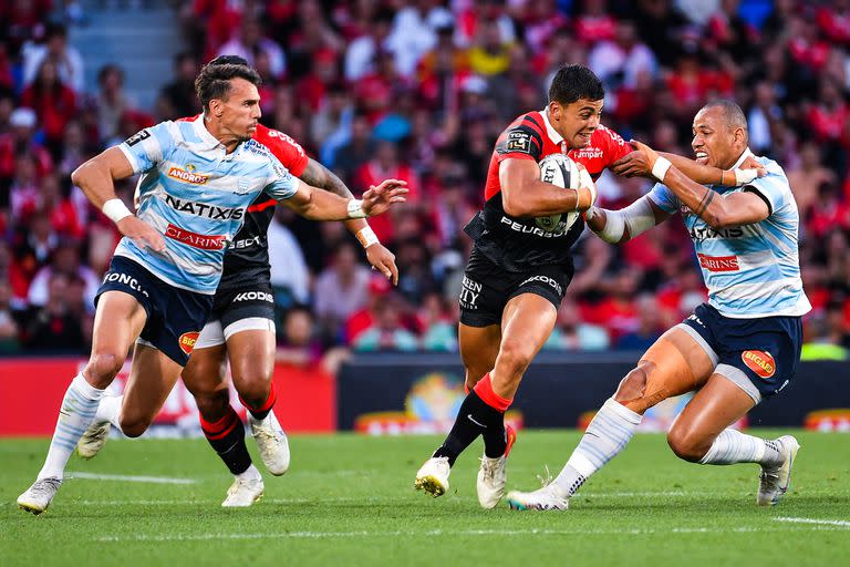 Santiago Chocobares, de Toulouse, rechaza un tackle de Gaël Fickou y Juan Imhoff, de Racing 92, acude en defensa, en la primera semifinal del Top 14, de Francia.