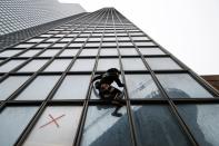 El escalador francés Alain Robert, también conocido como "hombre araña", escala el rascacielos del Tour Total en apoyo a los huelguistas de la reforma de las pensiones en el distrito financiero y de negocios de La Defense, cerca de París, Francia, el 13 de enero de 2020