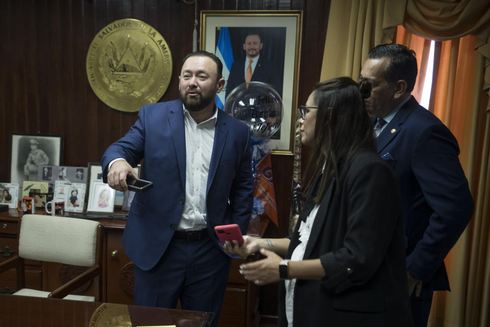 El Salvador’s Legislative Assembly Vice President Guillermo Gallegos is accompanied by staff members as he speaks during an interview in his office in San Salvador, El Salvador, Friday, Oct. 14, 2022. Gallegos sees no reason to lift the ongoing state of exception anytime soon. He noted that more people were being released on bail, which he took as a sign that the system was working. (AP Photo/Moises Castillo)