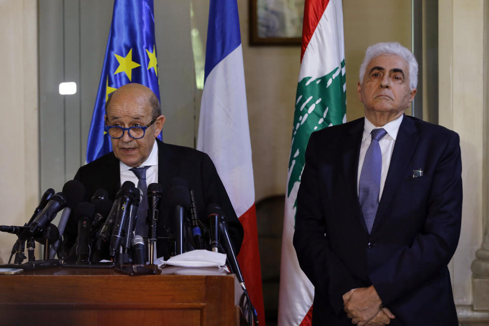 FILE - In this July 23, 2020, file photo, Lebanese Foreign Minister Nassif Hitti, right, and his French counterpart Jean-Yves Le Drian hold a news conference following their meeting at the Lebanese foreign ministry in Beirut, Lebanon. Lebanon's foreign minister has resigned, becoming the first cabinet minister to step down from his post amid a severe economic and financial crisis in the country. Minister Nassif Hitti's submitted resignation to the prime minister Monday, Aug. 3, 2020 and left the government house without making any comments. (AP Photo/Bilal Hussein, File)