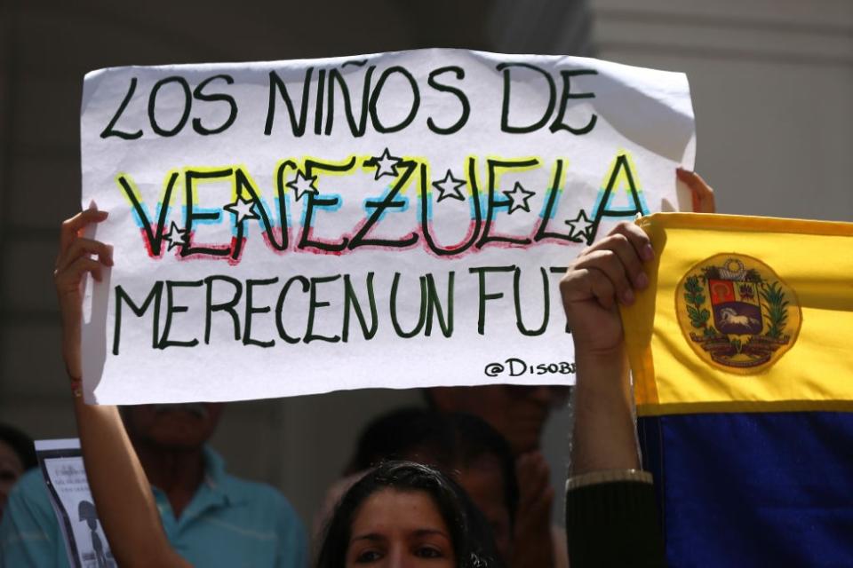 Una manifestante con una pancarta que dice: Los niños de Venezuela merecen un futuro