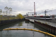 A train passes over a canal near the Hoboken Terminal in Hoboken, N.J., Tuesday, Oct. 27, 2020. The canal is part of a $200 million NJ Transit project to help prevent future flooding at Hoboken Terminal. (AP Photo/Seth Wenig)