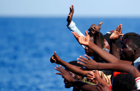 Migrants on a rubber boat gesture before they are rescued by the SOS Mediterranee organisation during a search and rescue (SAR) operation with the MV Aquarius rescue ship (not pictured) in the Mediterranean Sea, off the Libyan Coast, September 14, 2017. REUTERS/Tony Gentile