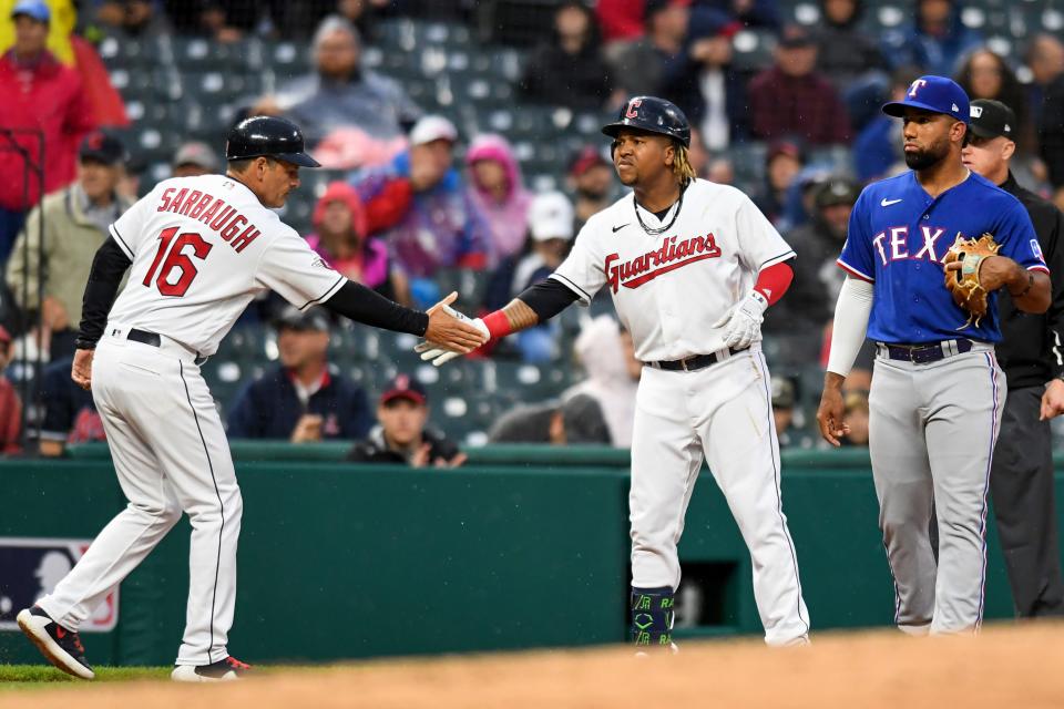 Cleveland Guardians' Jose Rami­rez, right, shakes hands with third base coach Mike Sarbaugh (16) after Ramirez hit an RBI double against the Texas Rangers during the third inning of a baseball game, Wednesday, June 8, 2022, in Cleveland. (AP Photo/Nick Cammett)